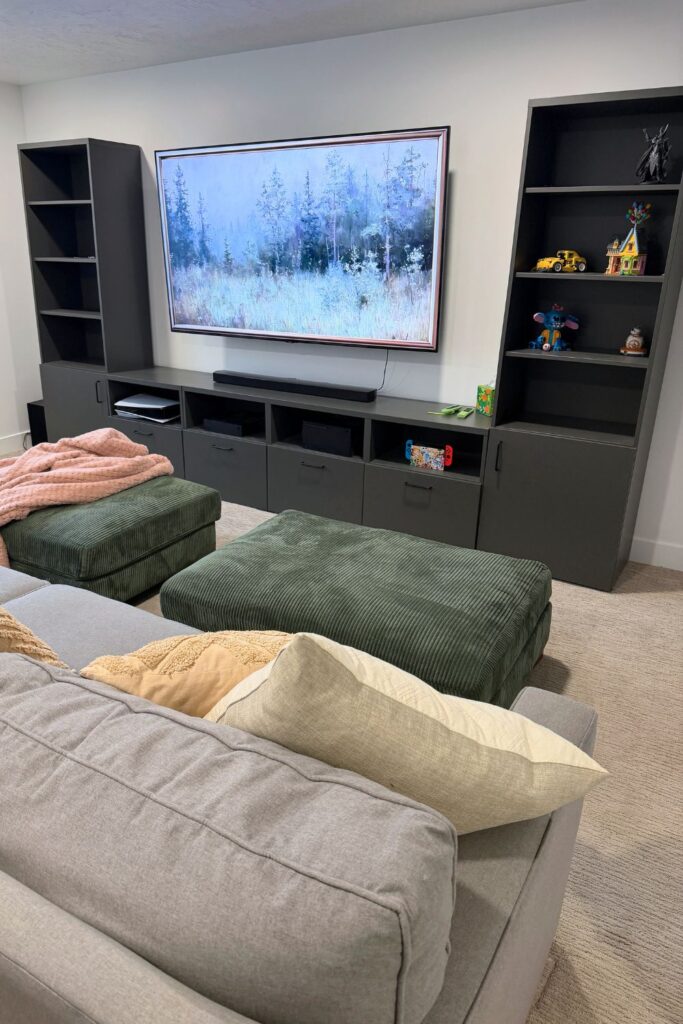 How to create a cozy media room  using IKEA cabinets, a comfortable couch, and simple accessories to build the perfect basement movie space.